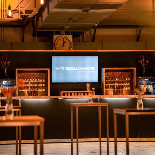 Indoor Ansicht der Alten Wollkämmerei mit romantischer Abendbeleuchtung und Blick auf die Bar.