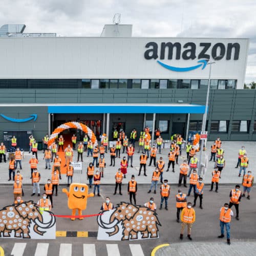 Live vor Ort bei amazon. Auf dem Vorplatz der Leipziger Zentrale sind die Mitarbeiter samt Maskottchen versammelt.
