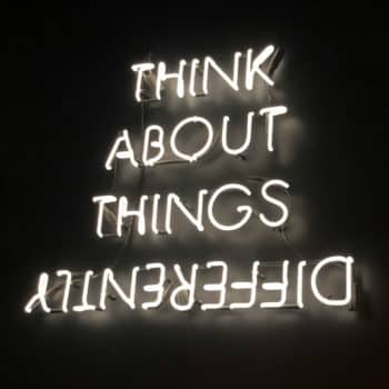 Ein Motto von uns als Leipziger Marketingagentur lautet "Think about things differently!" Hier visualisiert als leuchtender Neon-Schriftzug an einer schwarzen Wand.