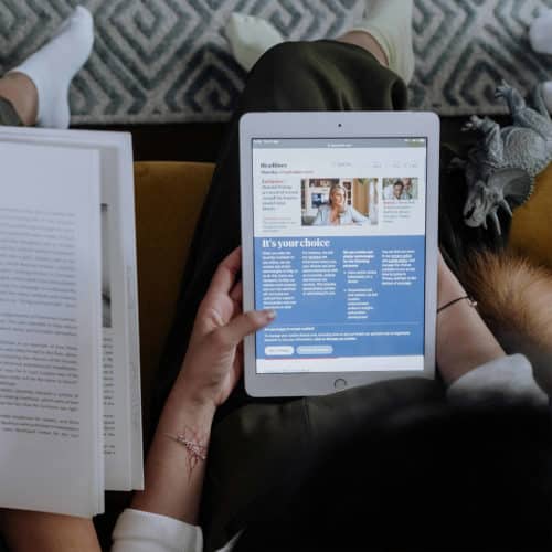 Blick auf ein Tablet auf dem Schoß einer Frau. Darauf geöffnet ist ein wissenschaftlicher Artikel einer Website. Thematisch für unsere Leistung Online Marketing.